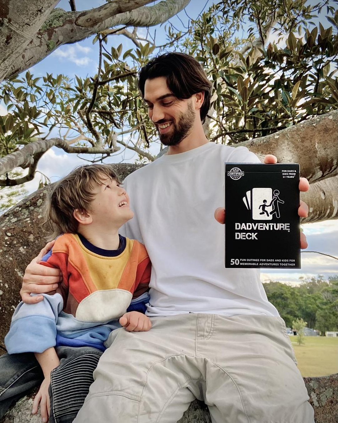 A dad and his kids choosing a Dadventure Deck activity card